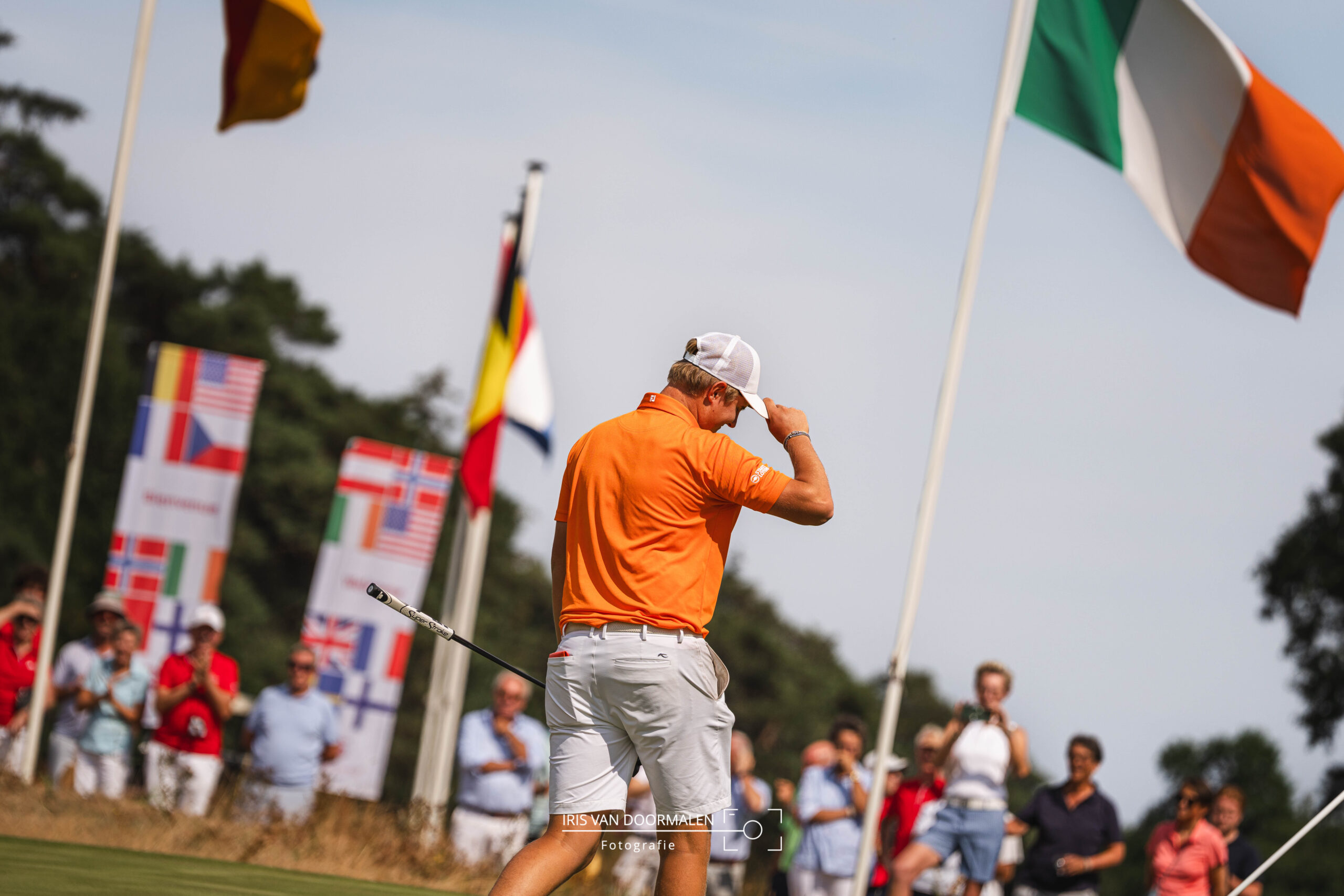 winnaar dutch amateur championship golf met applaudisserend publiek en internationale vlaggen op de achtergrond