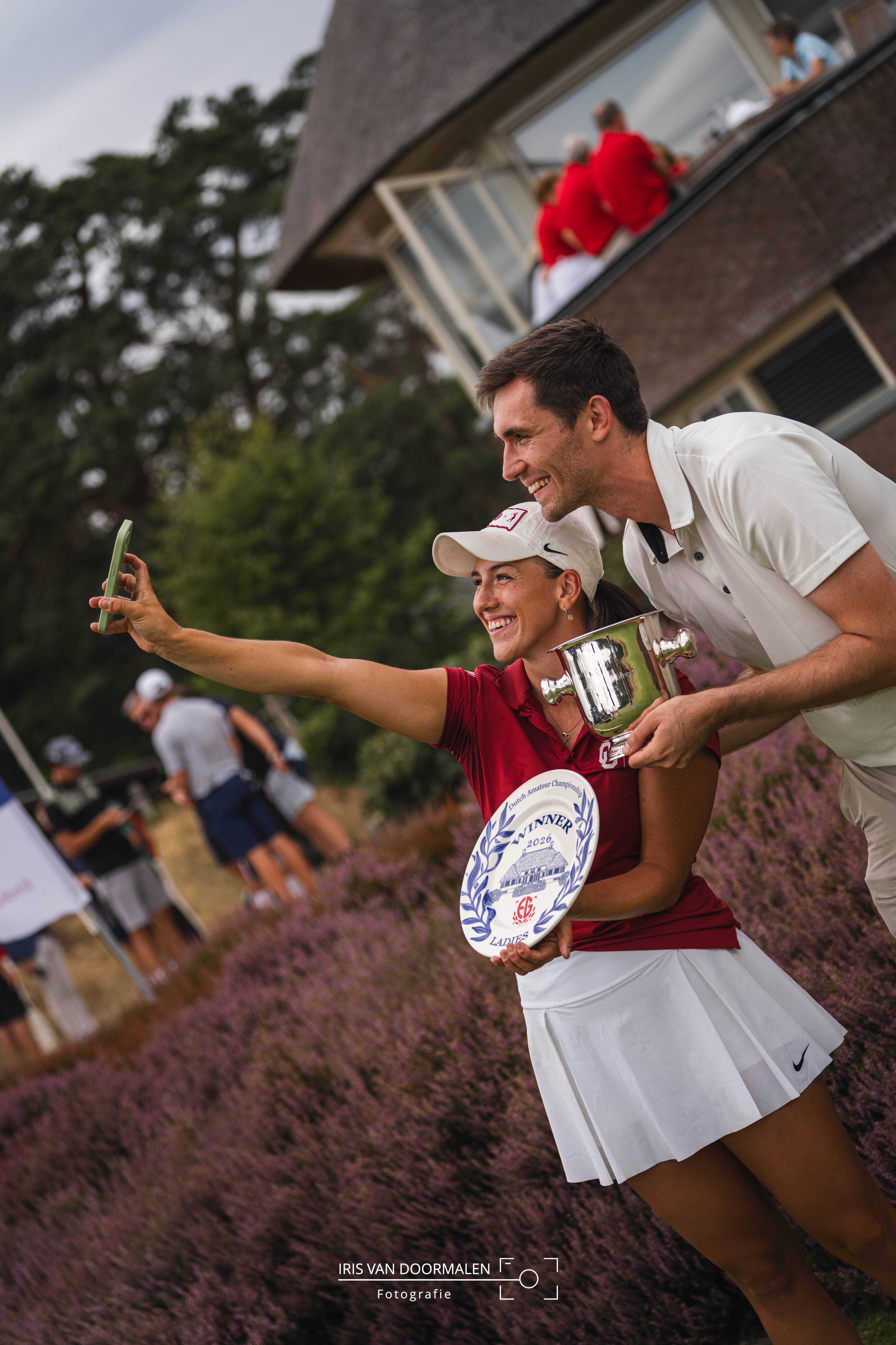 Winnares Nederlands Amateurkampioenschap golf maakt blije en trotse selfie met beker en schaal en vriendje