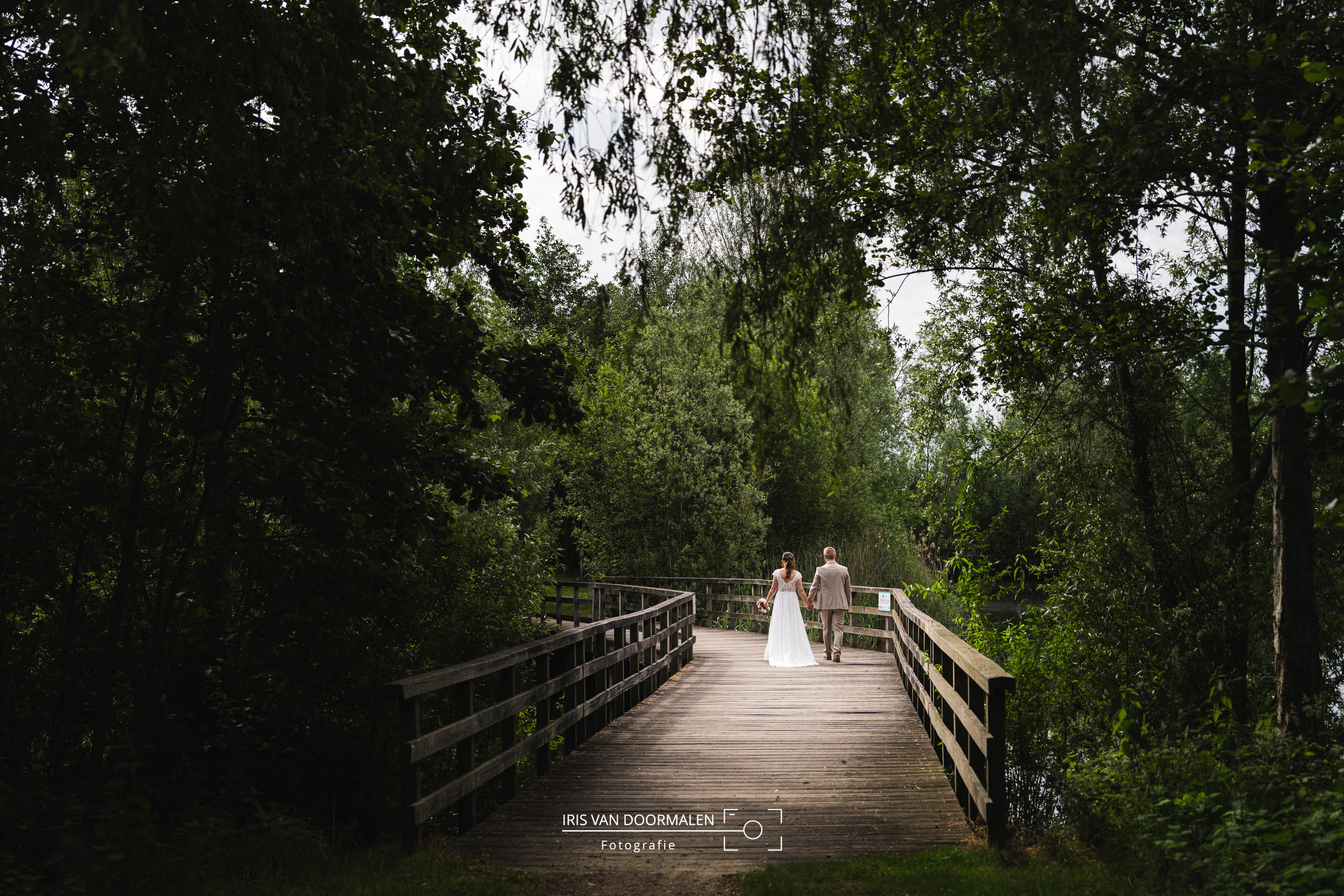 bruid en bruidegom lopen over brug