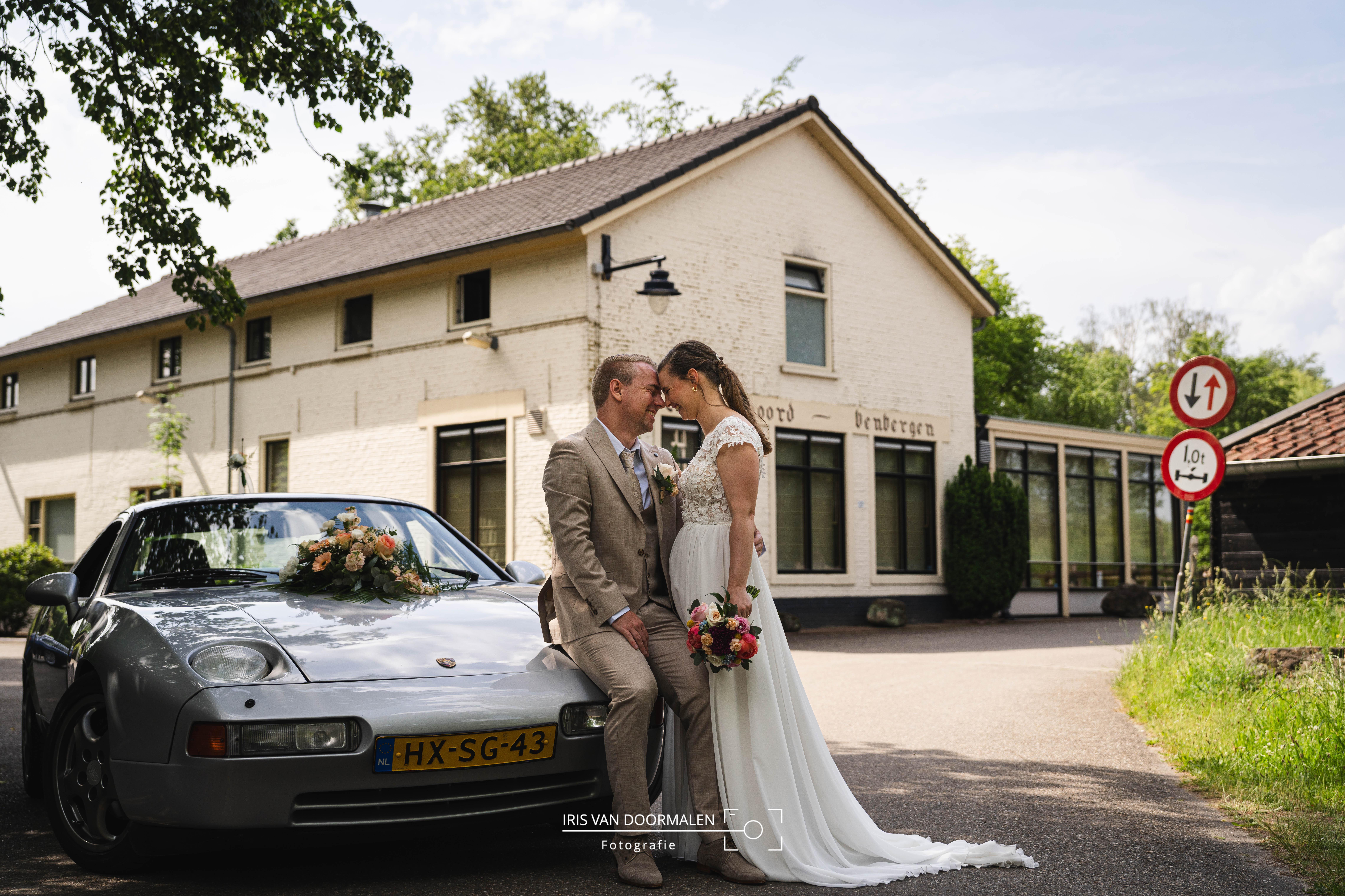 bruidspaar bij trouwauto en oud gebouw, watermolen